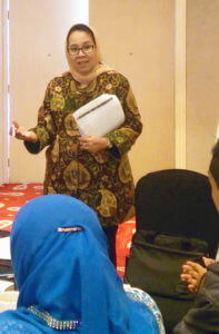 A woman lecturing in front of a group of people